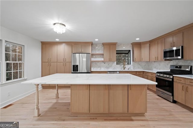 kitchen with decorative backsplash, a wealth of natural light, a center island, and stainless steel appliances