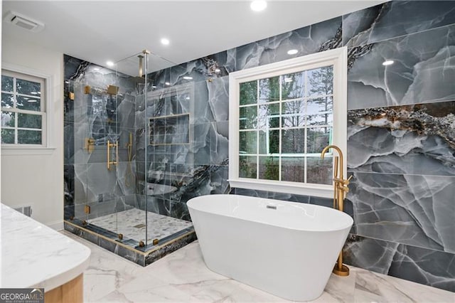 bathroom with tile walls and independent shower and bath