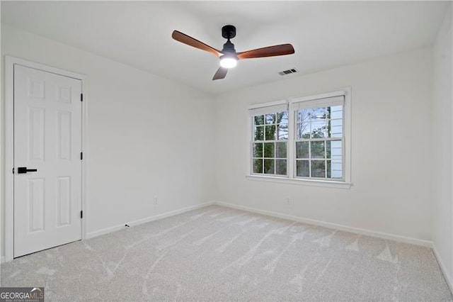 unfurnished room with ceiling fan and light carpet