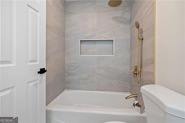 bathroom featuring toilet and tiled shower / bath