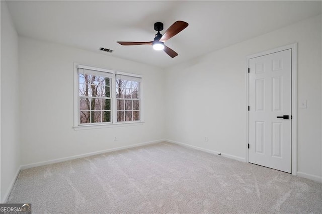 empty room featuring ceiling fan and light colored carpet