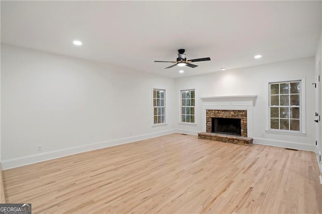 unfurnished living room featuring ceiling fan, light hardwood / wood-style floors, and a fireplace