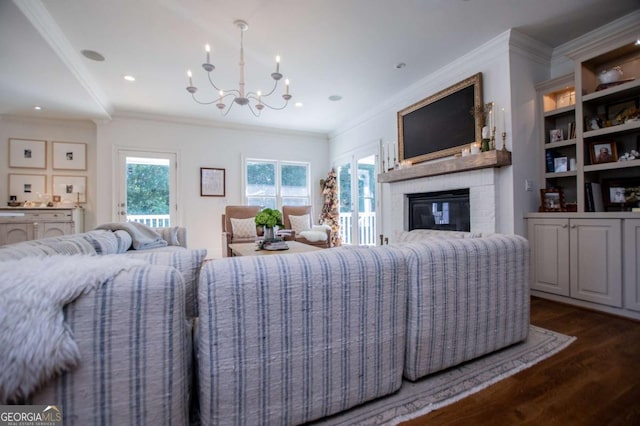 living room featuring a fireplace, ornamental molding, an inviting chandelier, and dark hardwood / wood-style flooring