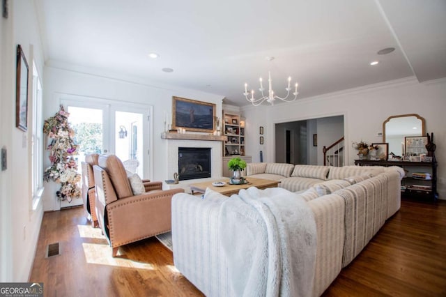 living room with hardwood / wood-style floors, crown molding, and a chandelier