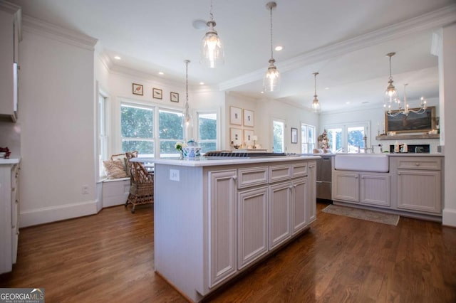 kitchen featuring sink, a center island, pendant lighting, and dark hardwood / wood-style flooring