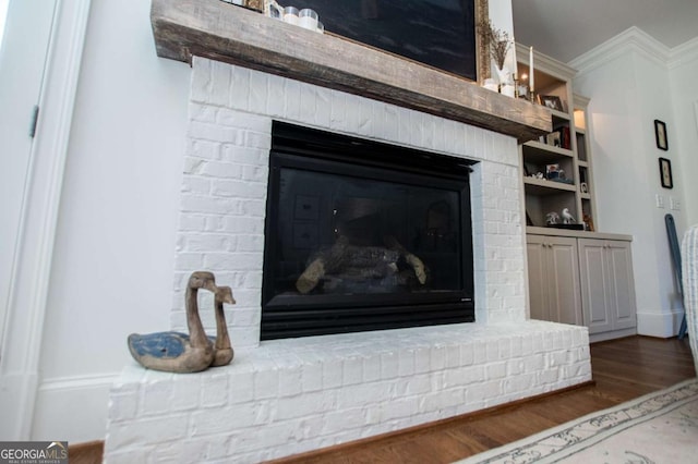 details with hardwood / wood-style flooring and a brick fireplace