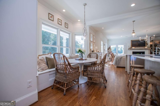 dining space with a notable chandelier, hardwood / wood-style flooring, and ornamental molding