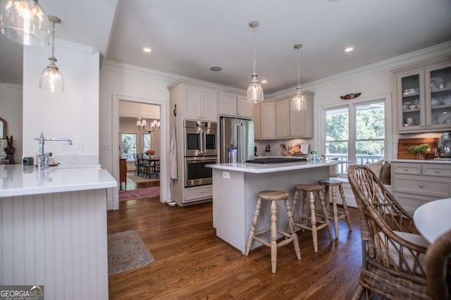 kitchen featuring decorative light fixtures, a breakfast bar area, dark hardwood / wood-style floors, and stainless steel appliances