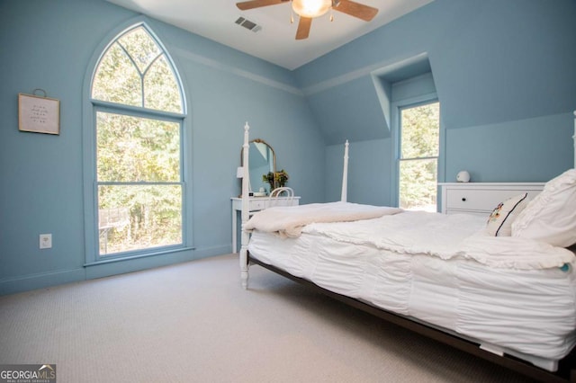 carpeted bedroom featuring ceiling fan, multiple windows, and lofted ceiling