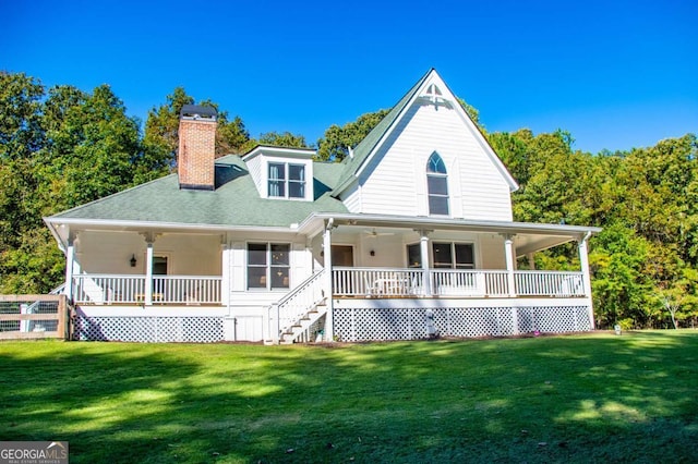 rear view of property with covered porch and a yard