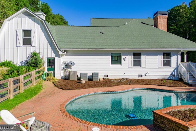 105 Fuller Dr, Carrollton, GA 30117 - back of property with fence, roof with shingles, a fenced in pool, board and batten siding, and a chimney