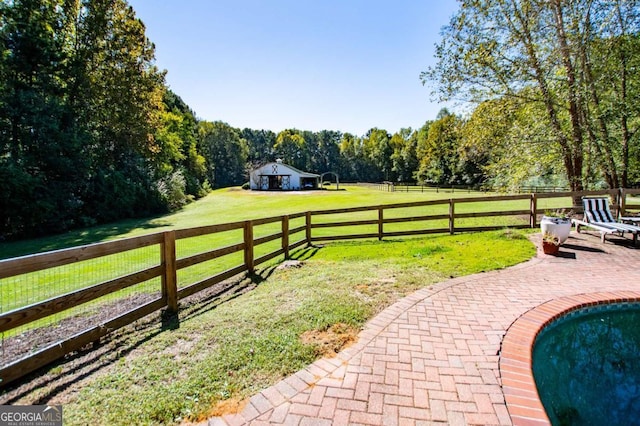 exterior space with a patio, a swimming pool, and a rural view