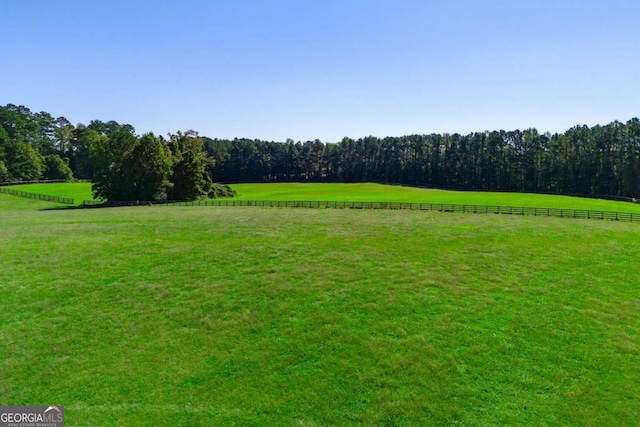 exterior space featuring a rural view and a yard