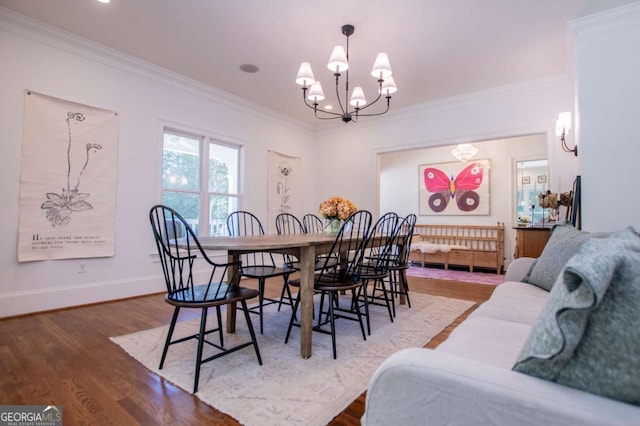 dining area with hardwood / wood-style floors, crown molding, and a chandelier