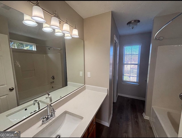 bathroom featuring vanity, hardwood / wood-style floors, shower / washtub combination, and a textured ceiling