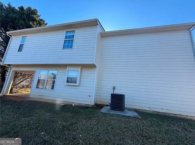 back of house with cooling unit and a yard