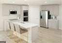 kitchen with a kitchen breakfast bar and white cabinets