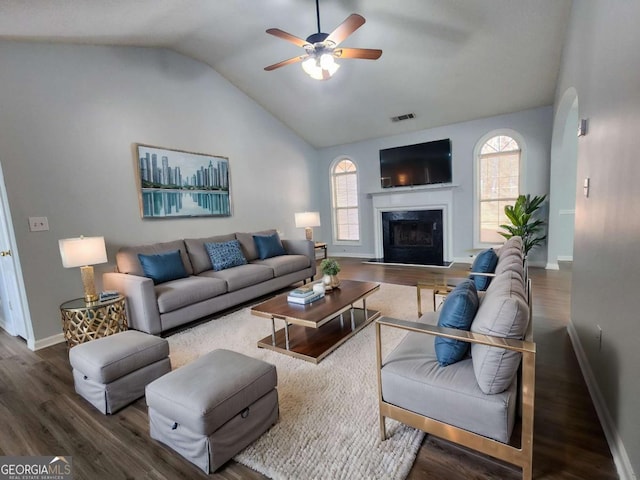 living room with a wealth of natural light, a high end fireplace, dark wood-type flooring, and lofted ceiling