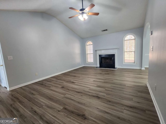 unfurnished living room with ceiling fan, vaulted ceiling, a high end fireplace, and dark hardwood / wood-style flooring