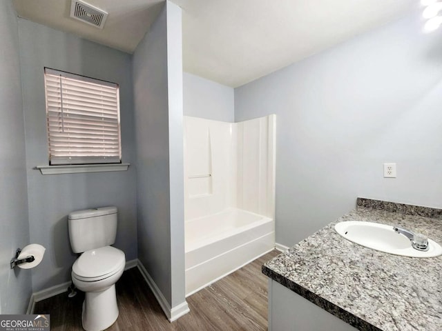 full bathroom with shower / washtub combination, hardwood / wood-style flooring, toilet, and vanity