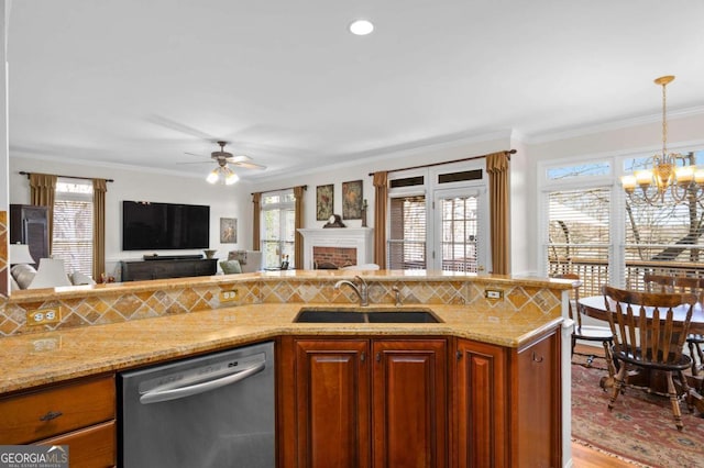 kitchen with stainless steel dishwasher, hanging light fixtures, sink, plenty of natural light, and ornamental molding