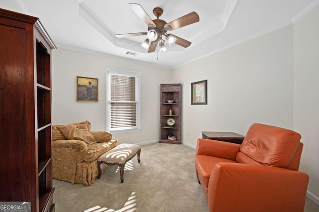 sitting room with crown molding, light carpet, and a tray ceiling