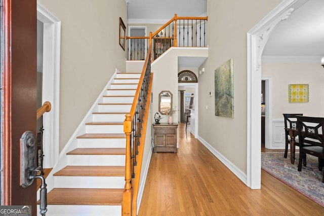 entrance foyer with hardwood / wood-style flooring and crown molding