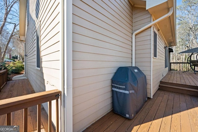 wooden deck featuring a grill