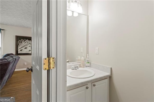 bathroom featuring vanity, wood-type flooring, and a textured ceiling