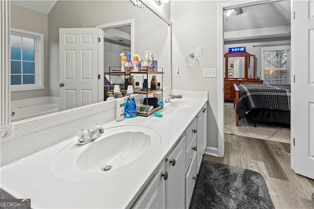 bathroom featuring vaulted ceiling, vanity, and hardwood / wood-style floors