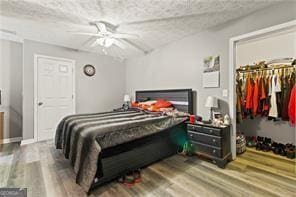 bedroom with hardwood / wood-style floors, a textured ceiling, and ceiling fan