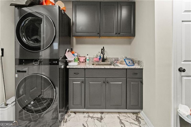 clothes washing area featuring cabinets, stacked washer / drying machine, and sink