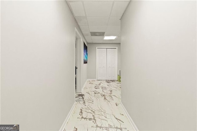 hallway with a paneled ceiling