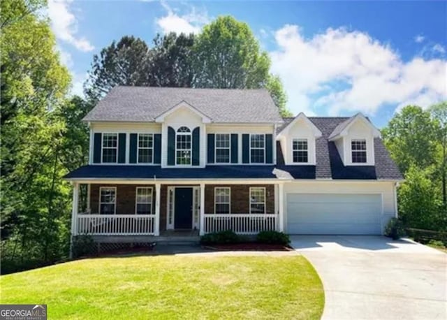 colonial inspired home with a garage, covered porch, and a front lawn