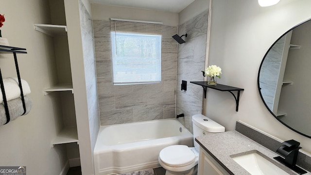 full bathroom featuring tiled shower / bath, vanity, and toilet