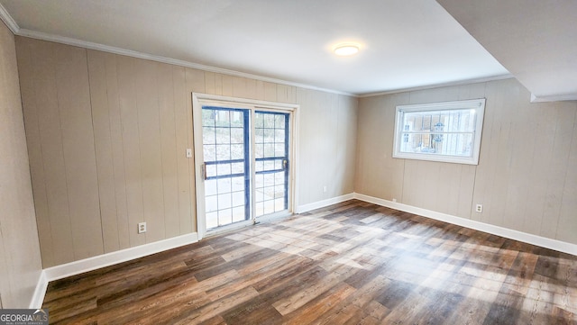 empty room with hardwood / wood-style flooring and crown molding