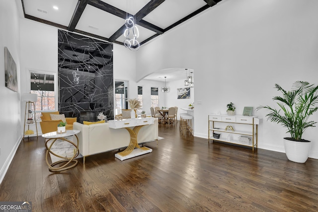 living room with coffered ceiling, beam ceiling, dark hardwood / wood-style floors, and a chandelier