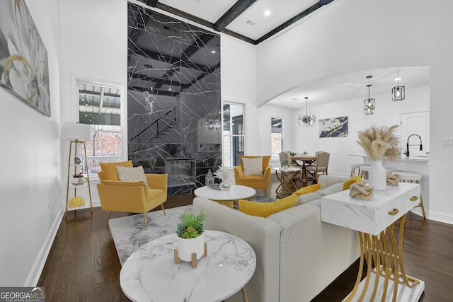 living room with sink, beam ceiling, a fireplace, and a healthy amount of sunlight