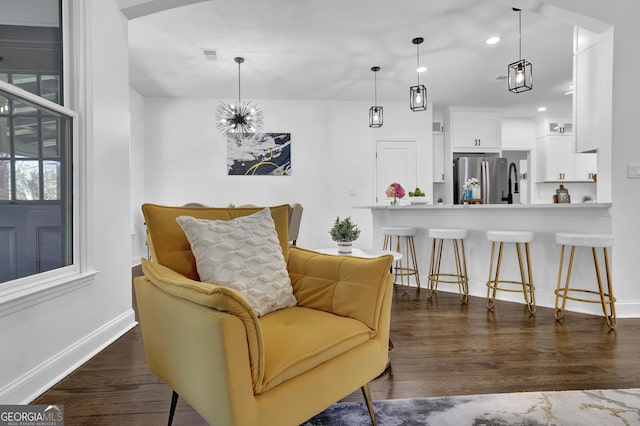 living area featuring dark hardwood / wood-style floors and an inviting chandelier