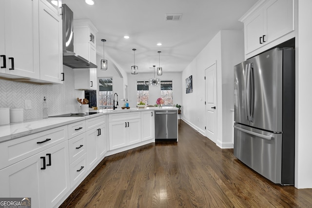 kitchen with sink, white cabinetry, appliances with stainless steel finishes, kitchen peninsula, and pendant lighting