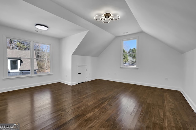 additional living space featuring dark hardwood / wood-style floors and vaulted ceiling