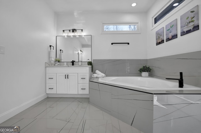 bathroom with a relaxing tiled tub and vanity