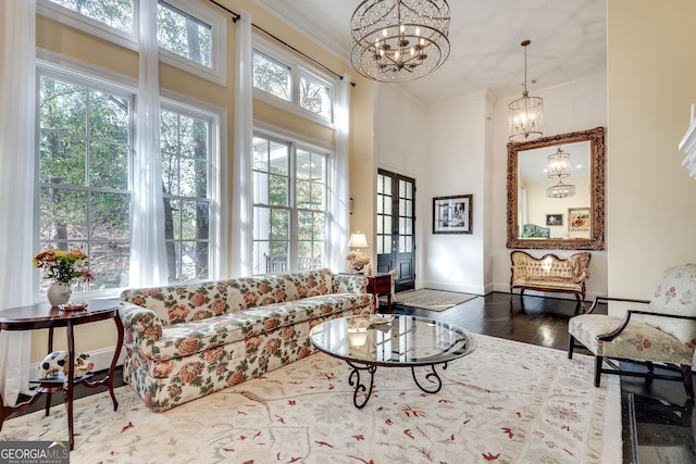 living room featuring an inviting chandelier, crown molding, hardwood / wood-style flooring, and a wealth of natural light