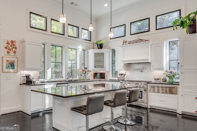 kitchen with a kitchen bar, stainless steel appliances, a kitchen island, and white cabinets