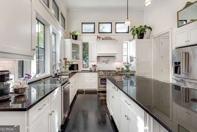 kitchen featuring sink, dark stone countertops, appliances with stainless steel finishes, decorative backsplash, and white cabinets