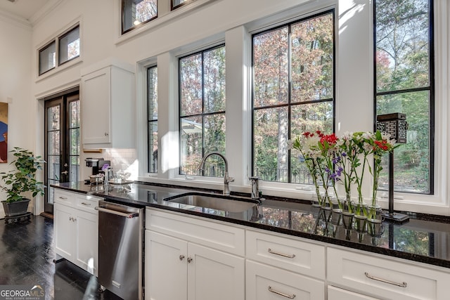 kitchen featuring dishwasher, white cabinetry, sink, dark stone counters, and ornamental molding