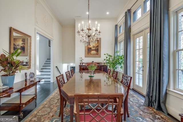 dining area with crown molding, an inviting chandelier, and dark wood-type flooring