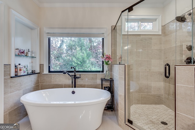 bathroom with tile walls, plenty of natural light, and separate shower and tub