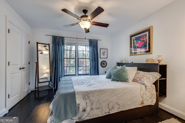 bedroom featuring dark hardwood / wood-style flooring, ceiling fan, and a closet