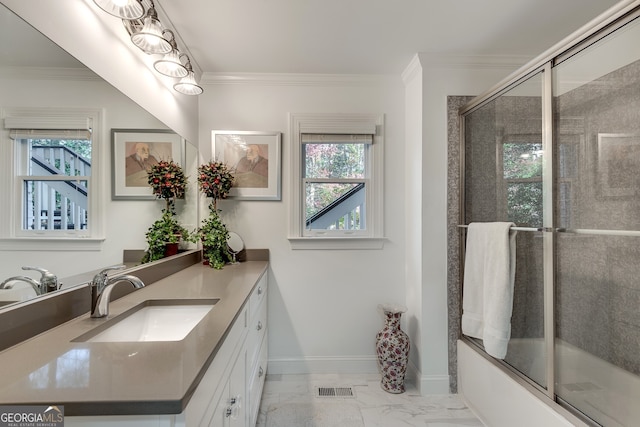 bathroom with vanity, combined bath / shower with glass door, a wealth of natural light, and crown molding